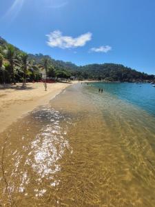 安格拉杜斯雷斯Angra dos Reis, Angra Inn, Cantinho perfeito的海滩上有人在水中游泳