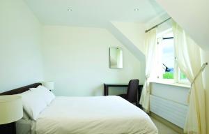 肯梅尔Ring Of Kerry HC No 20的白色的卧室设有床和窗户