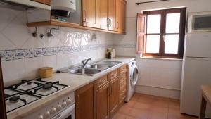 米尔芳提斯城Casa BARCA DO SOL的厨房配有水槽和炉灶