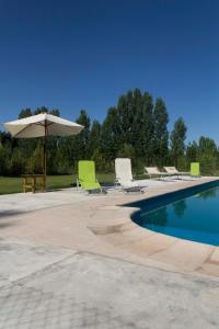 图努扬Avalenn, Casa de Campo的游泳池配有躺椅、遮阳伞和桌子