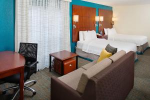 安大略安大略机场原住客栈 的酒店客房配有两张床、一张沙发和一张书桌。
