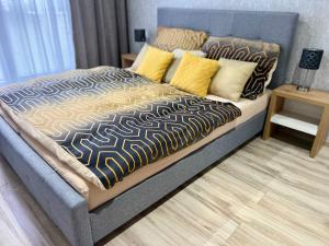 波切尼斯Apartman De lux 85m2的一间卧室配有一张带黄色枕头的大床