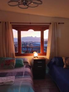 乌斯怀亚Ushuaia magnífica, cabaña 3 dormitorios的一间卧室设有一张床和一个美景窗户。