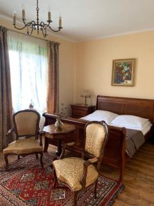 KrzyweDwór na Wrzosowisku的卧室配有一张床和一张桌子及椅子