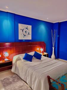 卢戈Motel Montecarlo的一间拥有蓝色墙壁和一张大床的卧室