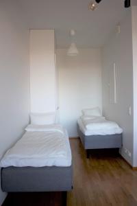 坦佩雷MM City Apartment Ratina Close to Arena的配有白色墙壁和木地板的客房内的两张床