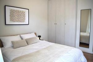 卡拉马塔KAPA Central Apartment的卧室配有白色的床和镜子