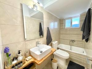 卡拉马塔KAPA Central Apartment的浴室配有盥洗盆、卫生间和浴缸。