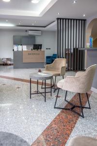 布德瓦加尔尼MB酒店的大堂设有两把椅子、一张桌子和一个柜台