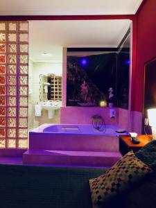 卢戈Motel Montecarlo的大型浴室设有紫色照明浴缸