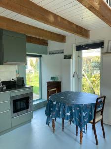济里克泽TIJ Tiny house aan het getijdewater in Zierikzee的厨房配有一张桌子,上面有蓝色的桌布