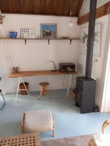 济里克泽TIJ Tiny house aan het getijdewater in Zierikzee的客房设有书桌和燃木炉。