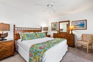 维雷亚Polo Beach Club - CoralTree Residence Collection的一间卧室配有一张床、一把椅子和镜子