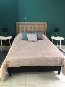 奇莱西托Sayani Posada的卧室设有一张大床和两张桌子