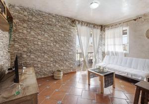 洛西洛斯Graciosa Sunset Apartment的带沙发和砖墙的客厅