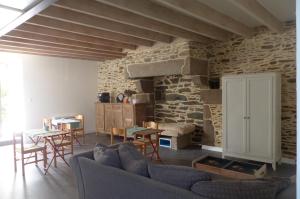 普莱讷富热尔Maison d'hôtes KerCalow, Chambres d'hôtes的带沙发和石墙的客厅