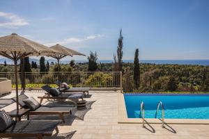 费斯卡尔德宏Luxury Villa Karmaniolos Fiskardo Kefalonia的一座别墅,设有游泳池,旁边还有人坐在椅子上