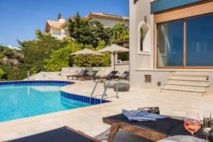 费斯卡尔德宏Luxury Villa Karmaniolos Fiskardo Kefalonia的一个带游泳池和庭院的别墅