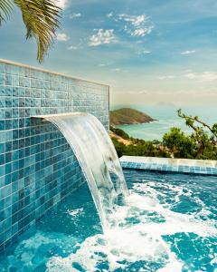 布希奥斯Buzios Mar Hotel & Spa的度假村内带瀑布的小型游泳池