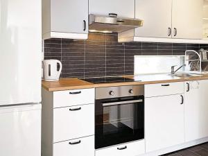 PålstorpHoliday home RAA HELSINGBORG的厨房配有白色橱柜和炉灶烤箱。