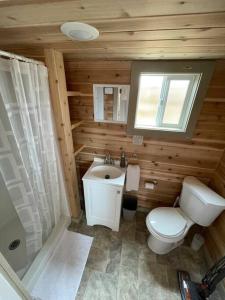 瓦莱Grand Canyon Hideaway Tiny home的木制浴室设有卫生间和水槽