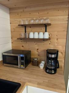 瓦莱Grand Canyon Hideaway Tiny home的厨房柜台配有微波炉和咖啡壶