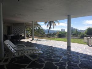阿卡普尔科Casa con vista espectacular al mar con alberca的一个带两把椅子和一张桌子的庭院和一棵棕榈树