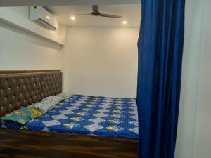 德奥加尔CHINTA HARAN REST HOUSE的蓝色窗帘的房间的一张床位