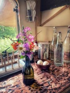 班特里Truck & Pod creative nature retreat.的一张桌子,上面有花瓶和瓶子