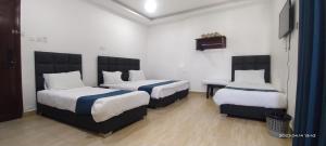 亚喀巴Happy Beach For Studio Rooms Apartment的酒店客房设有两张床和电视。