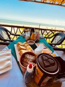 特赖里Pousada Paradise Flecheiras的一张桌子,上面有食物,享有海景