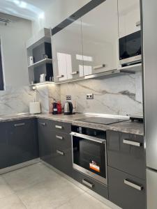 罗德镇Psaropoula's Hidden Gem的厨房配有灰色橱柜和炉灶烤箱