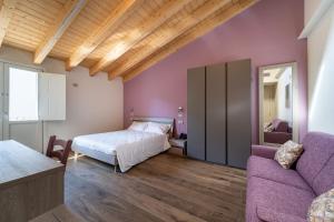 圣马蒂诺德拉巴Villa Veronesi的一间卧室配有一张床和一张沙发
