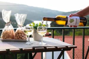 Regouro - an Hidden Gem in Douro Valley的把白葡萄酒倒进桌子上的两杯
