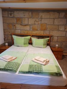 OttendorfFerienhaus Bildhauer Thiele的一张带绿色床单和毛巾的床