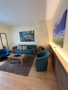 鲁马Guest House A'storia的客厅配有蓝色的沙发和桌子
