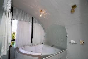 卡内拉Cabanas Boutique Aton的白色的浴室设有浴缸和镜子