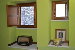 斯波莱托Casa Borgo Marco e Cristina的绿色客房配有电视和微波炉
