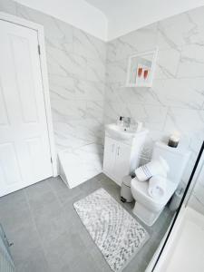 NorthfieldLuxurious family home in West Midlands的白色的浴室设有卫生间和水槽。