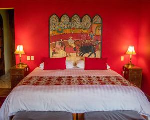 圣米格尔-德阿连德Casa Don Pascual Hotel Boutique Sweet Home的红色卧室设有一张红色墙壁的大床