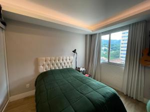 里约热内卢Duas Suítes e o Cristo Redentor的一间卧室设有一张床和一个大窗户