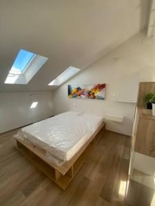 库尼奥Deliziosa mansarda con vista panoramica的一间带床的卧室,位于带窗户的房间内