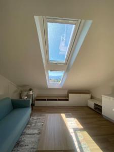 库尼奥Deliziosa mansarda con vista panoramica的客厅设有天窗和蓝色沙发。