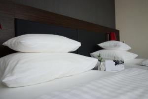 格拉茨Best Western Plus Plaza Hotel Graz的床上铺有白色枕头的床