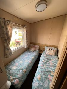 Kirby MispertonN and B caravan hire Flamingo Land的小房间设有两张床和窗户
