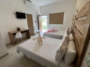 圣克鲁斯华特库Condominios JAROJE的酒店客房设有两张床和电视。
