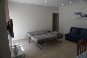 阿马多拉Sunny Home的一间卧室配有一张床和一张蓝色的沙发
