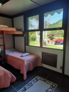 瓜鲁雅Casa Marina Guarujá的一间设有两张床的房间和一个带卡车的窗户