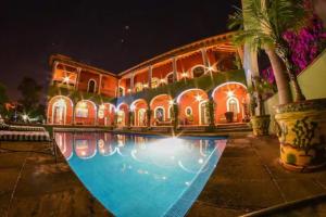 圣米格尔-德阿连德Casa Don Pascual Hotel Boutique Sweet Home的一座晚上设有游泳池的房子
