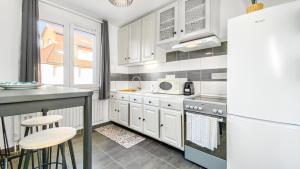 安姆比利HOMEY Coloc goodLife - Colocation moderne - Chambres privées - Wifi et Netflix - Au pied du tram pour Genève的厨房配有白色橱柜和冰箱。